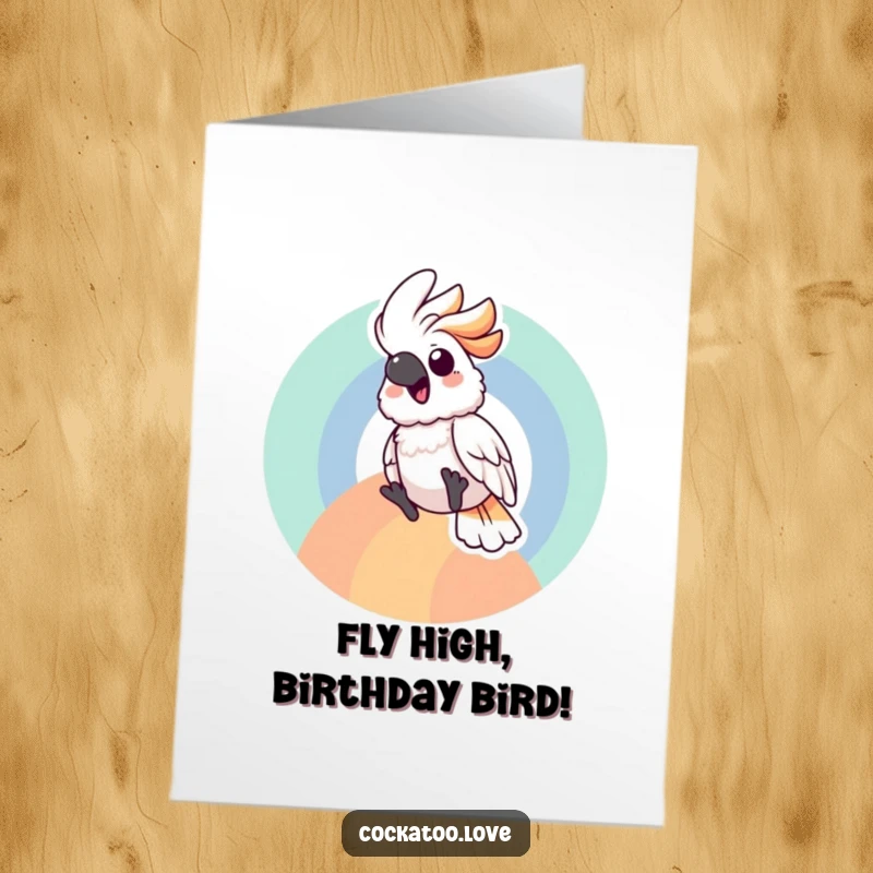 Cheerful free printable birthday card with a cockatoo character joyfully sliding down a colorful rainbow arc, embodying pure delight.